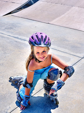 Girl riding on roller skates in skatepark in the park. Happy child.
