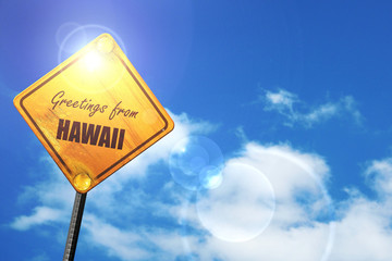 Yellow road sign with a blue sky and white clouds: Greetings fro