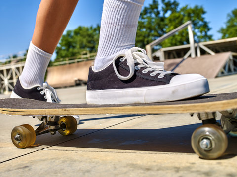 Legs skateboard close up  in skatepark. Low section. Foot on a skateboard.