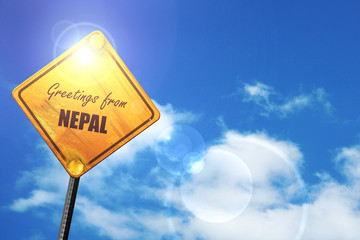 Yellow road sign with a blue sky and white clouds: Greetings fro