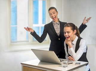 Two businesswomen work at the laptop