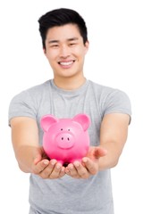 Fototapeta na wymiar Young man holding a piggy bank