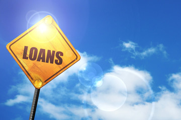 Yellow road sign with a blue sky and white clouds: loans