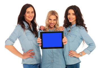 three smiling women showing you the screen of a tablet