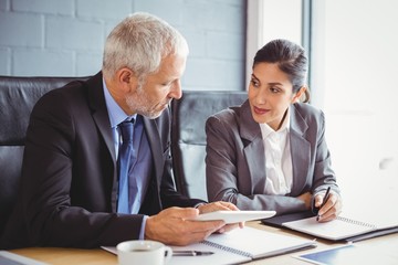 Businessman and businesswoman sitting in conference room