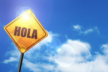 Yellow road sign with a blue sky and white clouds: hola © Argus