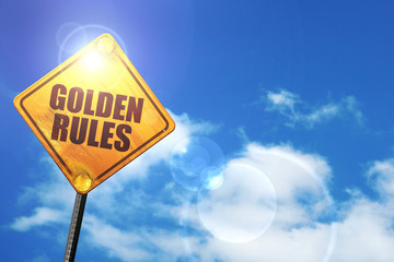 Yellow road sign with a blue sky and white clouds: golden rules