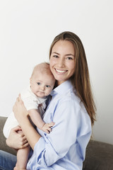 Gorgeous mother holding baby son, portrait