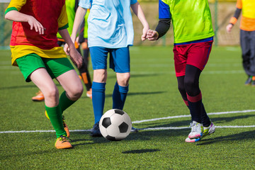 Fototapeta na wymiar Football soccer game of youth teams. Running young players kicking soccer ball
