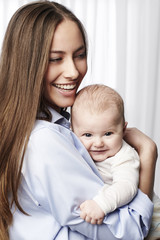 Smiling mother and baby, looking away