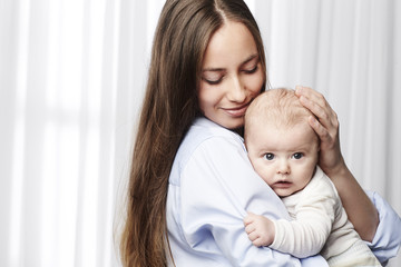 Mother and young baby embracing