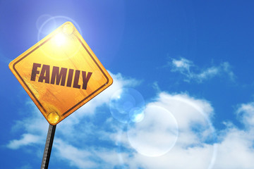 Yellow road sign with a blue sky and white clouds: family