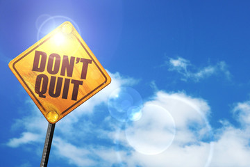 Yellow road sign with a blue sky and white clouds: don't quit
