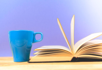 Color cup of tea with books on table