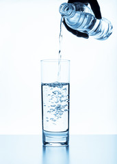 water pouring in glass isolated on white background
