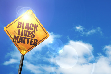 Yellow road sign with a blue sky and white clouds: black lives m
