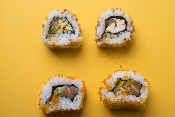 Various kinds of sushi food served on yellow blackground