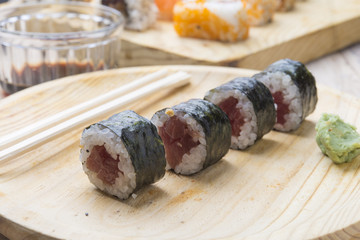 Different Sushi rolls,wasabi and ginger on a plate on wooden bac