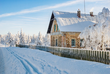 Winter scenery with small national park house challet, ski trail and snow covered trees with...