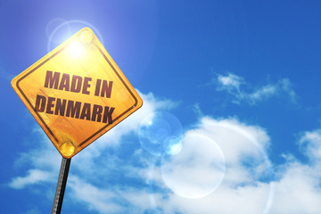 Yellow road sign with a blue sky and white clouds: Made in denma