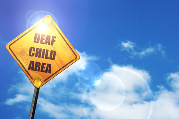 Yellow road sign with a blue sky and white clouds: Deaf child si