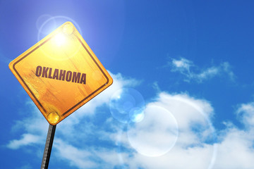 Yellow road sign with a blue sky and white clouds:  oklahoma