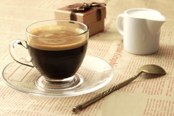 Coffee Cup With Espresso, Milk And  Gift Box On Newspaper