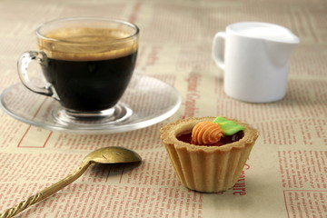 Coffee Cup With Espresso, Milk, Spoon And Biscuit On Newspaper