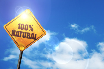 Yellow road sign with a blue sky and white clouds: 100% natural
