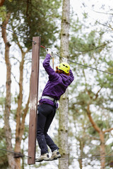 Woman on cables in an adventure park on a difficult course