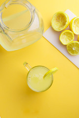 Water and lemon in yellow background