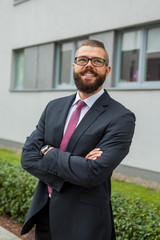 Portrait of a young happy businessman outside the office buildin