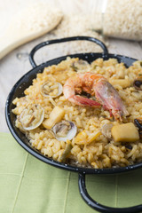 View from above of paella with seafood in a paellera on a wooden