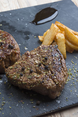 Grilled T-bone steak seasoned with spices and fresh herbs served