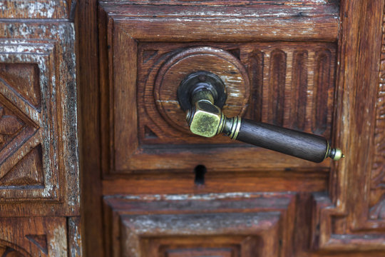 Vintage bronze door knob on handmade wood carving door