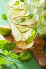 mojito cocktail and ingredients over green background