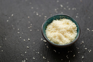 Coconut Flakes in Ceramic Bowl on Dark Background