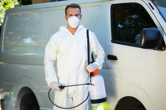 Portrait of pest control man standing next to a van