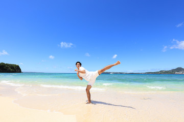 Fototapeta na wymiar 瀬底島の美しいビーチで寛ぐ男性