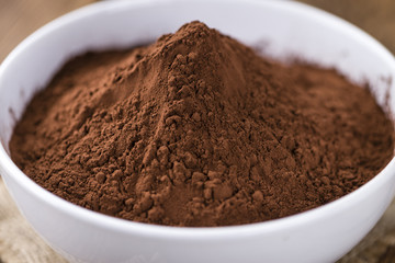 Cocoa powder on wooden background