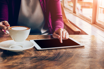 woman using tablet computer in coffee shop with vintage tone.