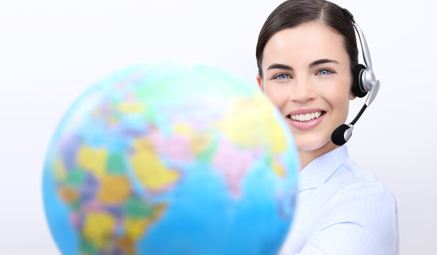 Customer service operator woman with headset smiling, holding globe