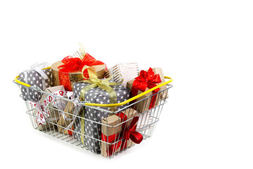 Shopping basket with gifts on white background