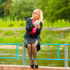 portrait of senior business woman with the tablet outdoors