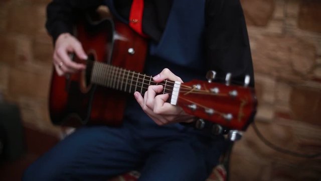 man playing on a 6-string acoustic guitar