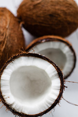 Whole and broken coconut on the white plank table. © cegli