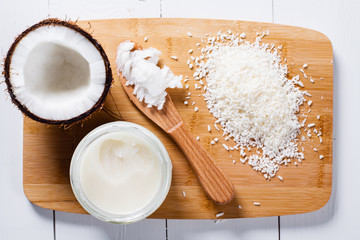 Whole and broken coconut with grated cocont flakes and coconut oil or butter.