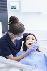 Beautiful woman patient having dental treatment at dentist's office. Woman visiting her dentist