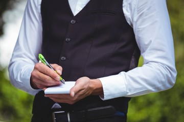 Handsome waiter writing the order