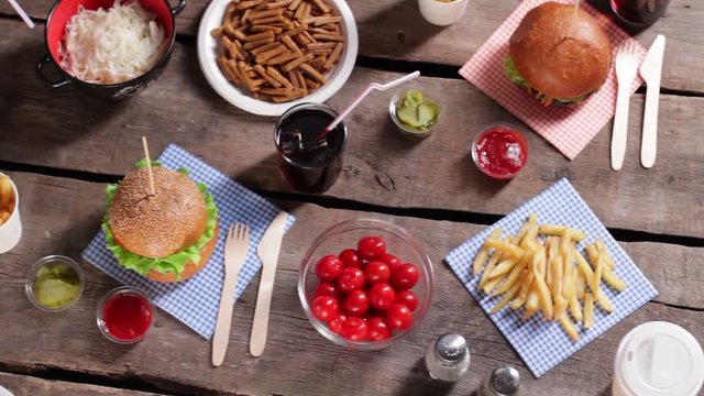 French fries and cherry tomatoes. Fries on brown wooden table. Junk food with different sauces. Retro diner table with food.